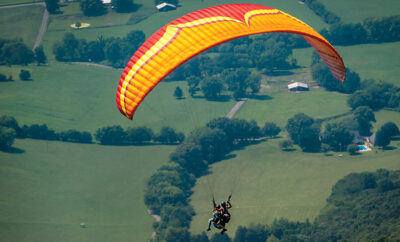 A tandem paragliding group take off from Flying Camp Paragliding near Dunlap.